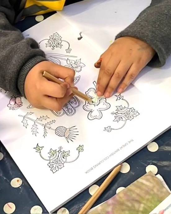 Child colouring a page from the colouring book